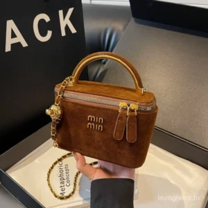 Bolsa vinho de veludo em destaque sendo usada com look casual. Bolsas Min em veludo