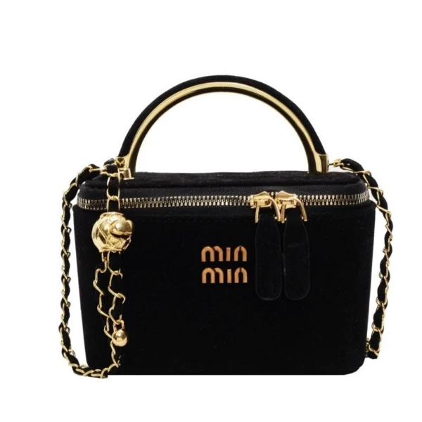 Bolsa de veludo preta com alça dourada e corrente decorativa dourada.